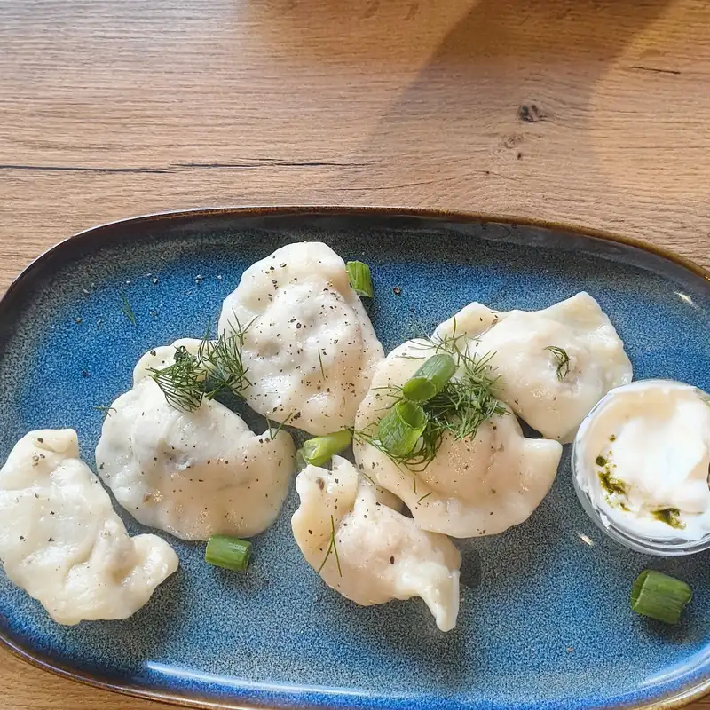Pierogi z zieleniną na niebieskim talerzu