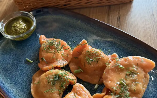 Smażone pierogi z zieleniną na granatowym talerzu